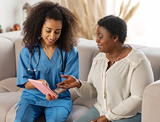 Home nurse going over charts with older woman
