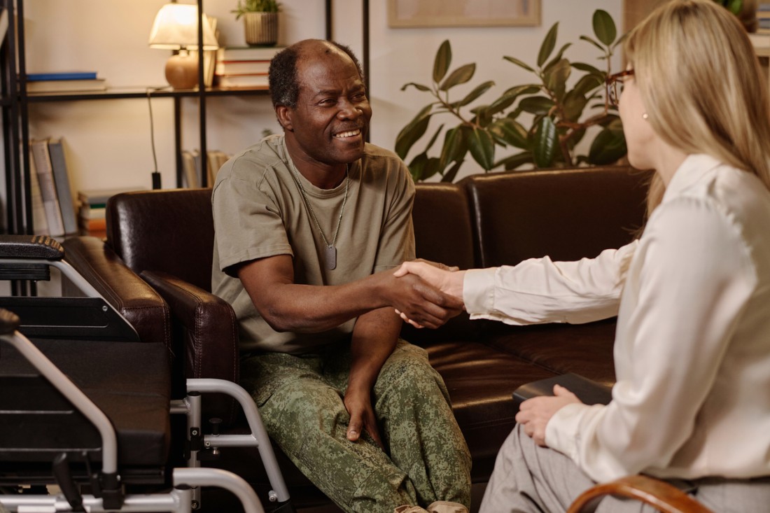 Veteran Support In-Home Care Services | ComForCare - veteran-in-wheelchair-shaking-hands-with-caregiver